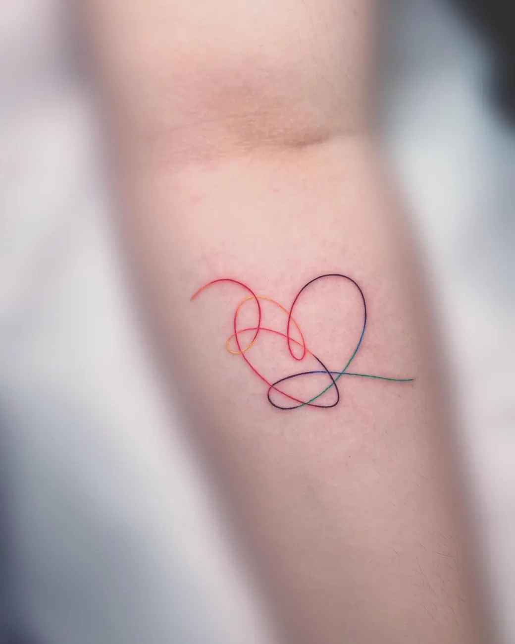 Tattoo: Single-line heart, forearm